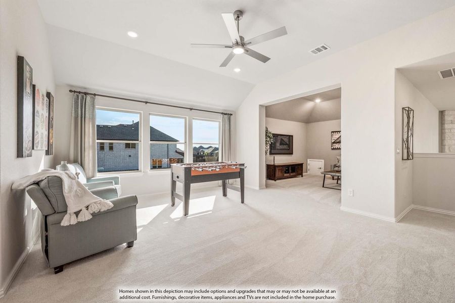 Bonus room with carpet, foosball table, ceiling fan, and open view into media room