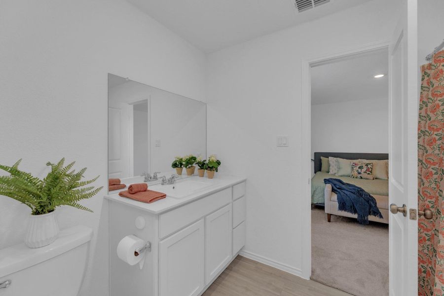 Ensuite bathroom featuring vanity and light wood-type flooring
