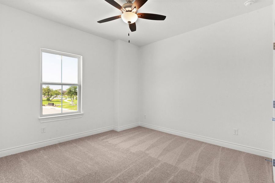 Carpeted room with a ceiling fan, white walls, and white trim