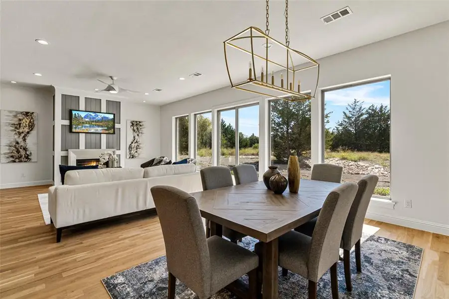 Dining space with ceiling fan, a healthy amount of sunlight, and light wood-type flooring