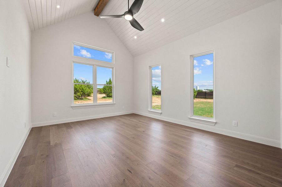 Spare room with beam ceiling, high vaulted ceiling, wood-style flooring, a ceiling fan, and recessed lighting