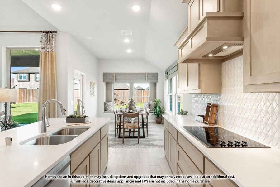 Open kitchen with beige cabinets, white countertops, and a view into the dining area with large windows