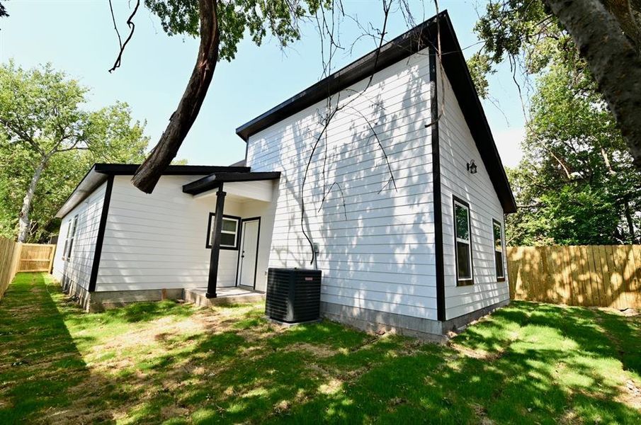 Rear view of property with a yard and cooling unit