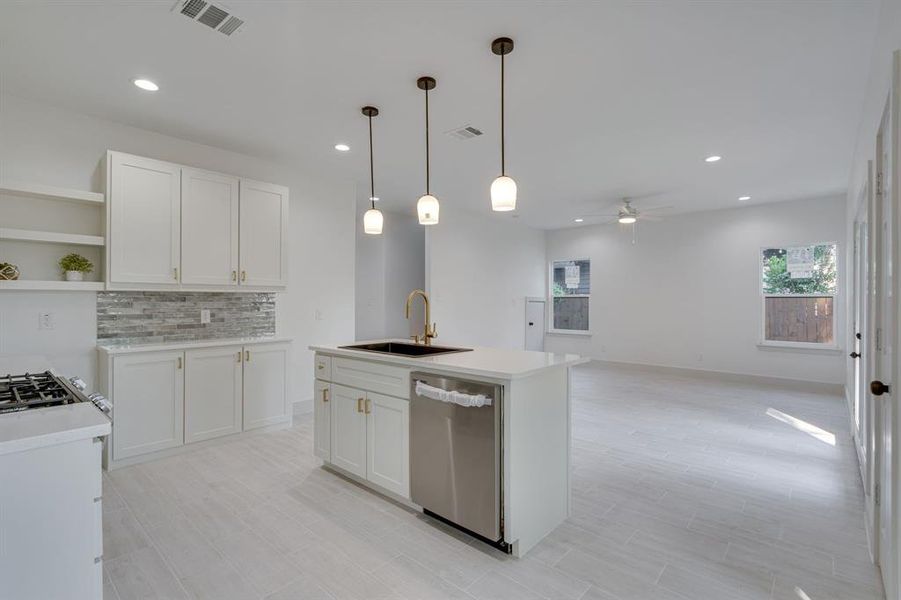 Kitchen featuring dishwasher, decorative light fixtures, sink, white cabinets, and ceiling fan