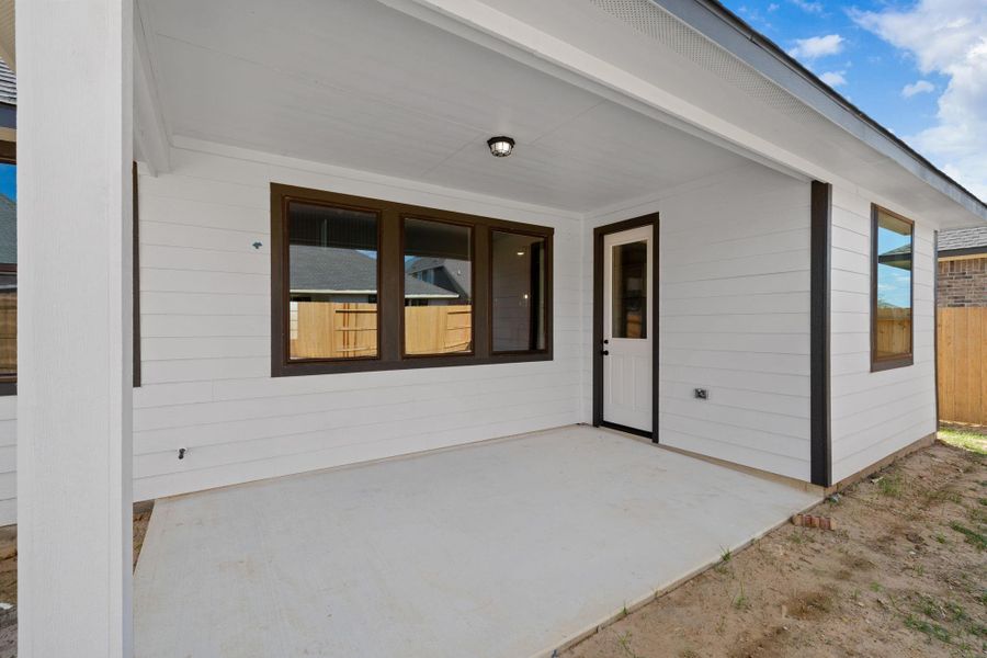 The covered patio is generously sized, providing ample space for various outdoor activities.