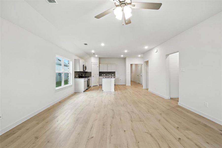 Unfurnished living room featuring light wood-style floors, recessed lighting, and ceiling fan