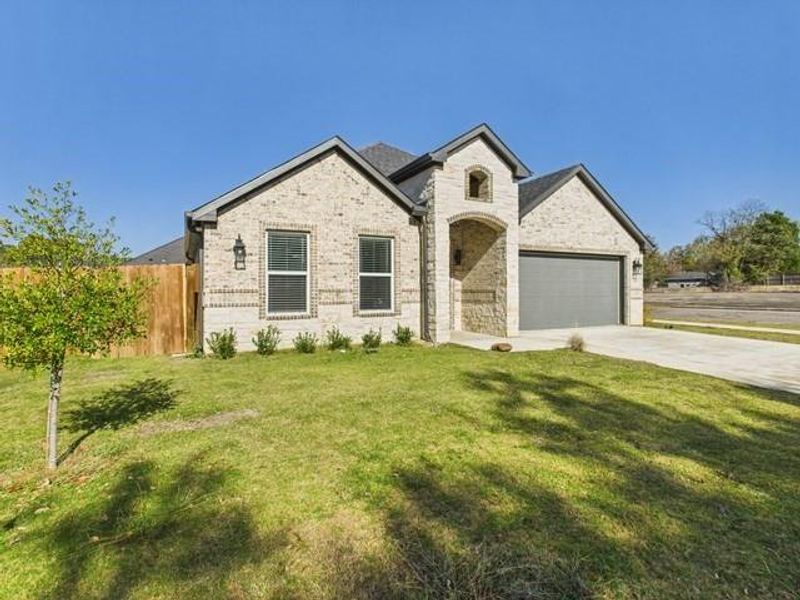 French provincial home with concrete driveway, brick siding, and an attached garage French provincial home with concrete driveway, brick siding, and an attached garage