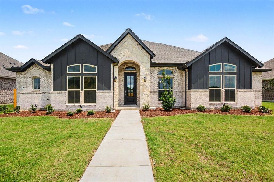 Stone and board-and-batten facade with dark trim windows Stone and board-and-batten facade with dark trim windows