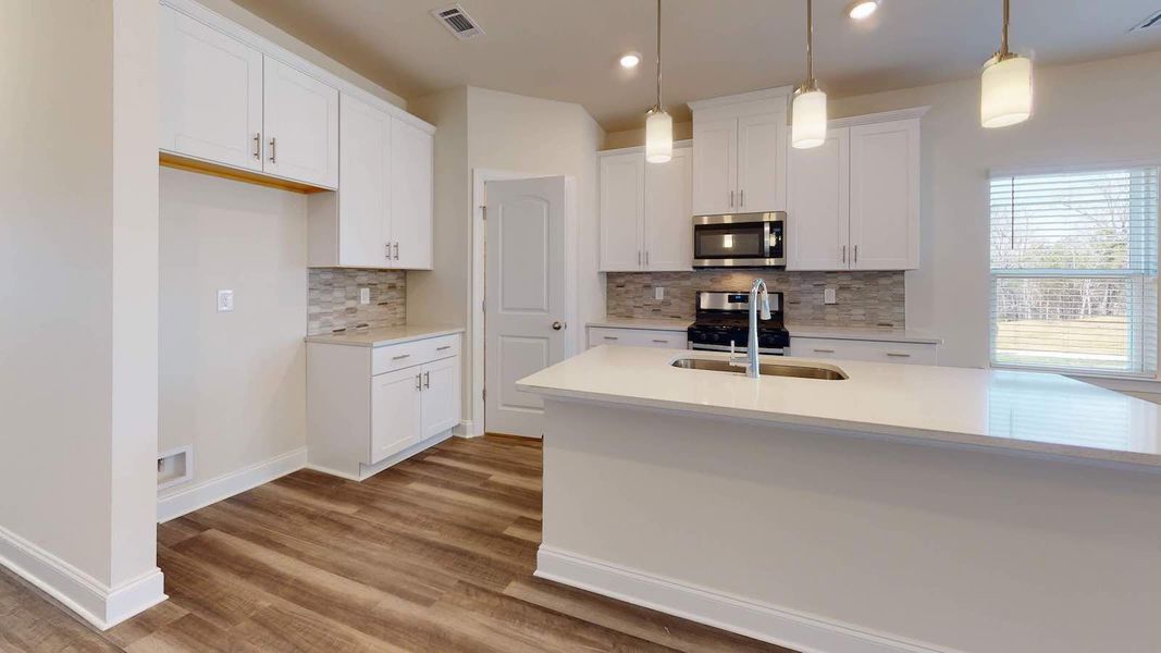 A large kitchen island anchors the open-concept floorplan. A large kitchen island anchors the open-concept floorplan.