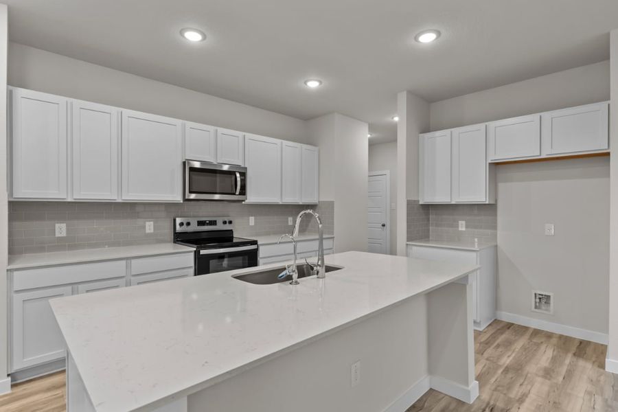 A kitchen with white cabinets.