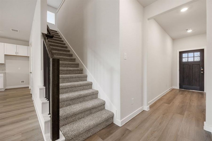 Upon entering you find a lovely corridor showcasing neutral paint, beautiful EVP floors, high ceilings, ample lighting a perfect line of sight to the spacious great room.