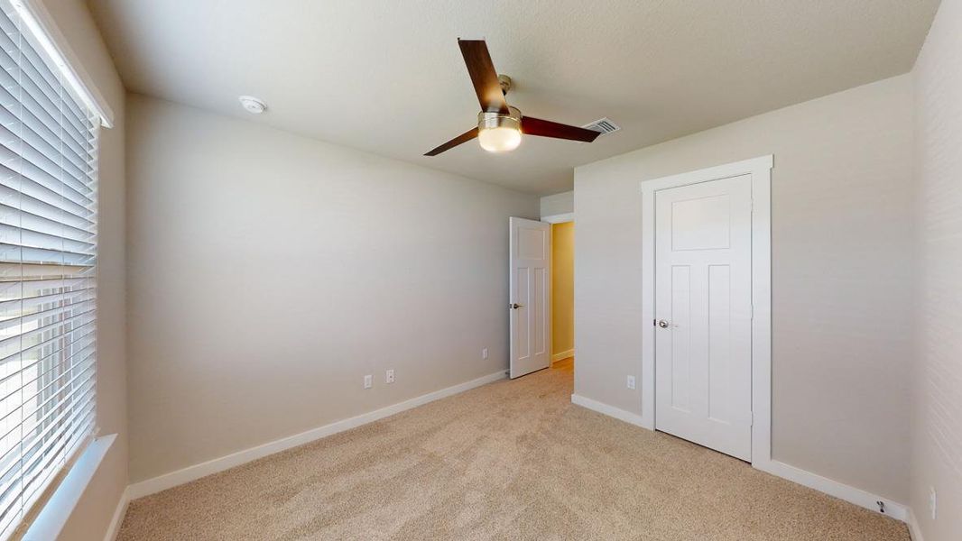 Unfurnished bedroom featuring light colored carpet and a ceiling fan