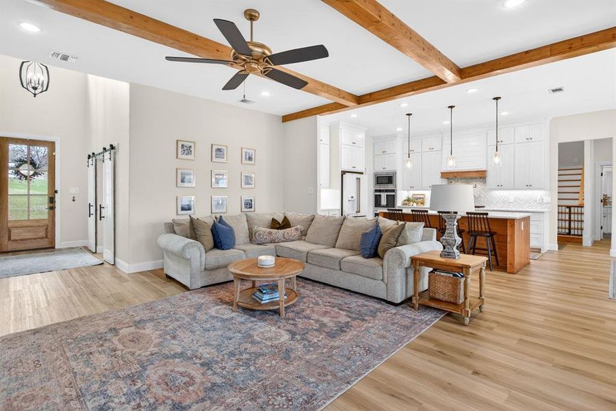 Living room with recessed lighting, light wood finished floors, ceiling fan, and beam ceiling Living room with recessed lighting, light wood finished floors, ceiling fan, and beam ceiling