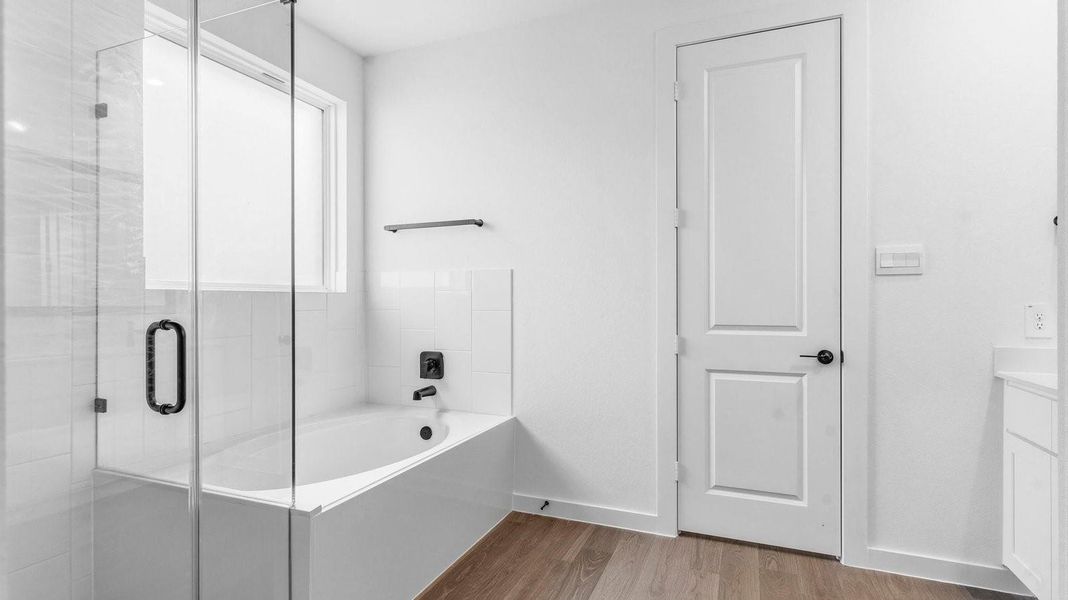 Primary bathroom with a glass-enclosed standing shower and separate soaking tub. Primary bathroom with a glass-enclosed standing shower and separate soaking tub.