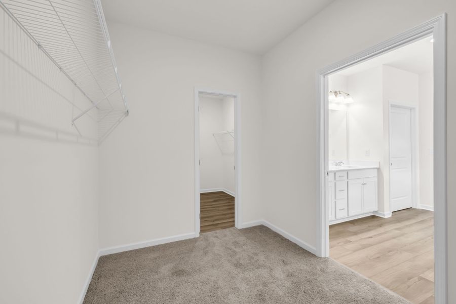 Huge primary walk in close with access to the laundry room (left) and primary en suite bathroom (right). Huge primary walk in close with access to the laundry room (left) and primary en suite bathroom (right).
