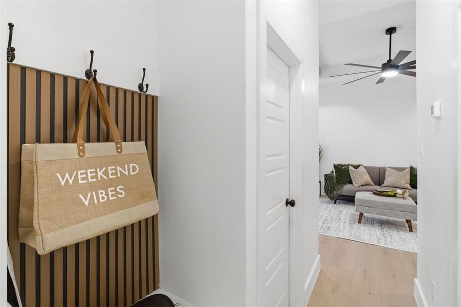 Entryway featuring a wood slat accent wall with integrated coat hooks