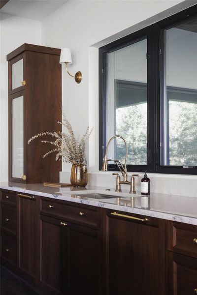A window to the Hill Country. The main kitchen sink is perfectly positioned to overlook the 1.06-acre backyard and greenbelt. Whether you're prepping a meal or cleaning up, you have a direct line of sight to the private pool and mature trees, making even the simplest daily tasks feel connected to the outdoors.