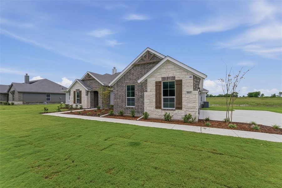 Exterior featuring a combination of brick and stone siding, decorative gable accents, and dark-framed windows with rustic wooden shutters Exterior featuring a combination of brick and stone siding, decorative gable accents, and dark-framed windows with rustic wooden shutters