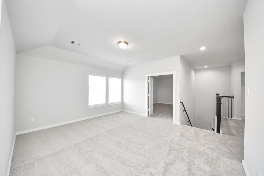 Come upstairs and relish a day of relaxation in this loft area! Ideal as an additional living space or game room, it boasts plush carpeting, high ceilings, custom paint, and windows that flood the area with abundant natural light. Come upstairs and relish a day of relaxation in this loft area! Ideal as an additional living space or game room, it boasts plush carpeting, high ceilings, custom paint, and windows that flood the area with abundant natural light.