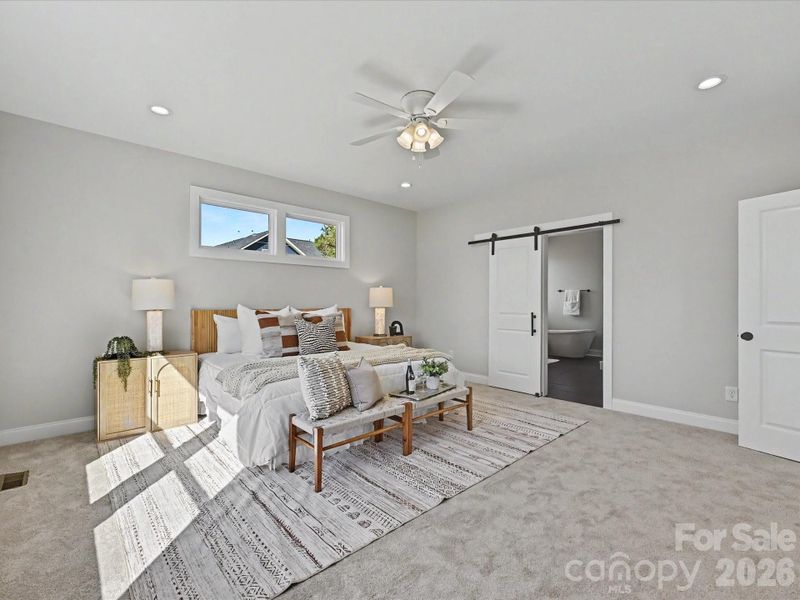 Spacious primary suite offers a peaceful retreat with abundant natural light, plush carpeting, and private access to the spa-inspired en-suite bath.