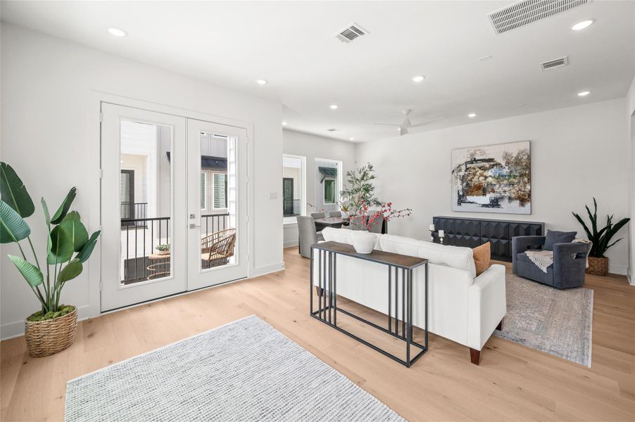 French doors open to a private balcony, creating a bright, airy atmosphere ideal for relaxing or entertaining.