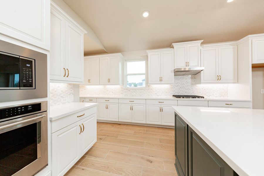 This gourmet, open-concept kitchen is truly the heart of the home, meticulously designed with both aesthetics and functionality in mind. White Shaker-style cabinetry that extends to the ceiling, offering maximum storage space. Quartz countertops, modern backsplash and gold-tones hardware giving it all a touch of luxury.