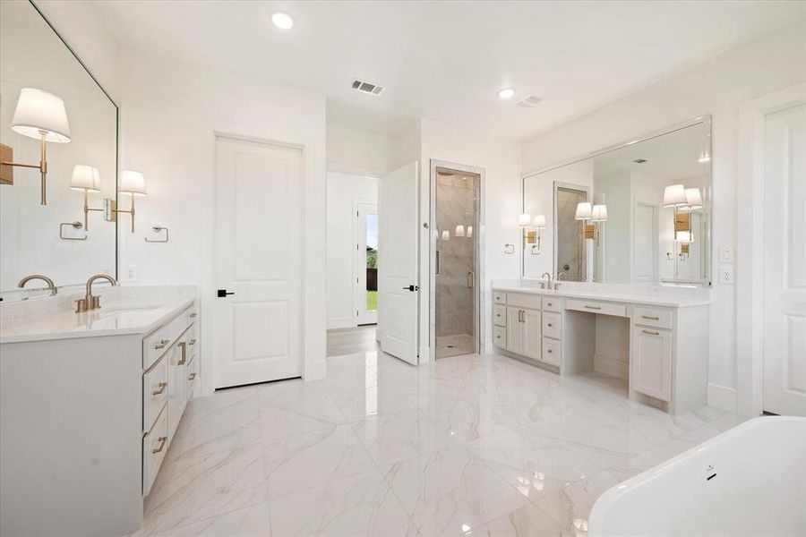 Bathroom featuring vanity and separate shower and tub