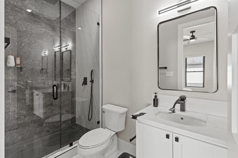 Bathroom with vanity, a marble finish shower, and ceiling fan
