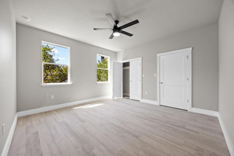 Unfurnished bedroom with baseboards, a ceiling fan, and wood finished floors Unfurnished bedroom with baseboards, a ceiling fan, and wood finished floors