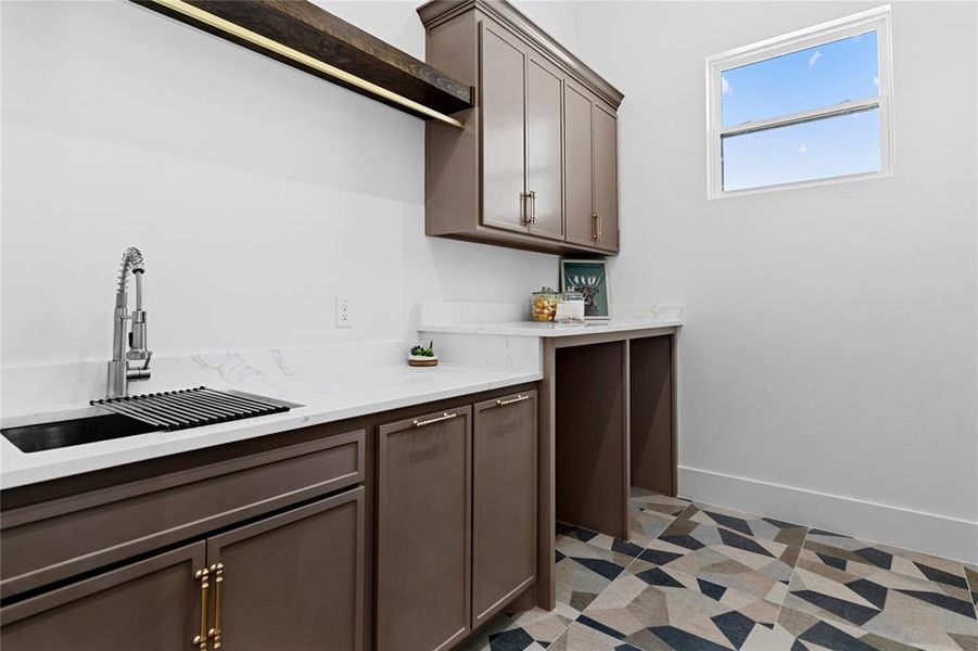 Laundry room with a sink and light quartz counters, custom cabinets. Laundry room with a sink and light quartz counters, custom cabinets.