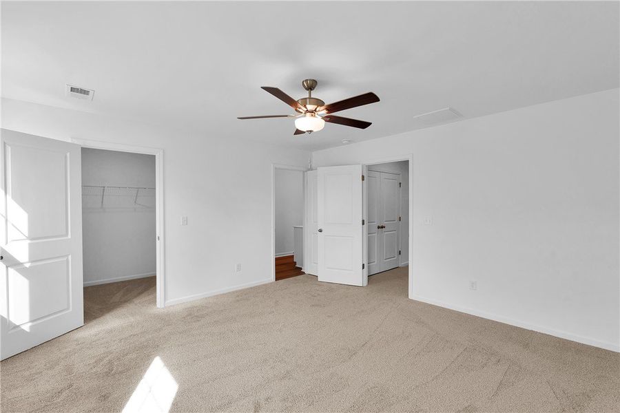 This spacious bedroom offers comfortable carpet fl