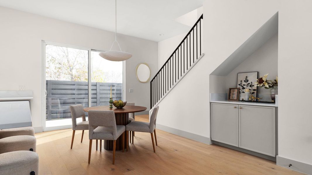 Dining space with stairs and light wood-style flooring