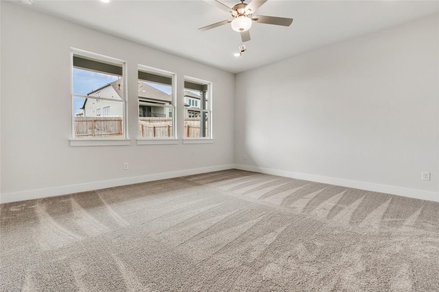 A well-proportioned bedroom with triple windows and soft carpeting offers a comfortable retreat.