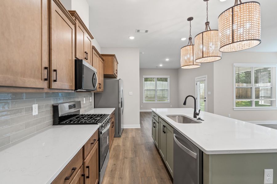 Kitchen featuring stainless steel appliances, an island with sink, dark wood-style flooring, pendant lighting, and recessed lighting