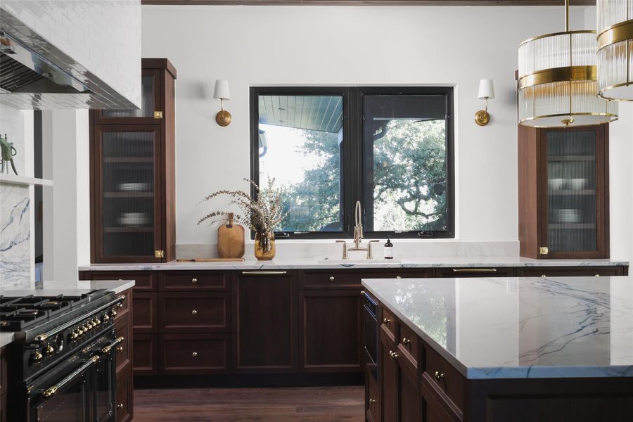 An intuitive kitchen floorplan. This wide shot shows the layout in action, where the Bertazzoni range, oversized island, and walk-in pantry are all positioned for maximum efficiency. It’s a space designed for someone who truly loves to cook, offering massive counter space without feeling disconnected from the rest of the home.