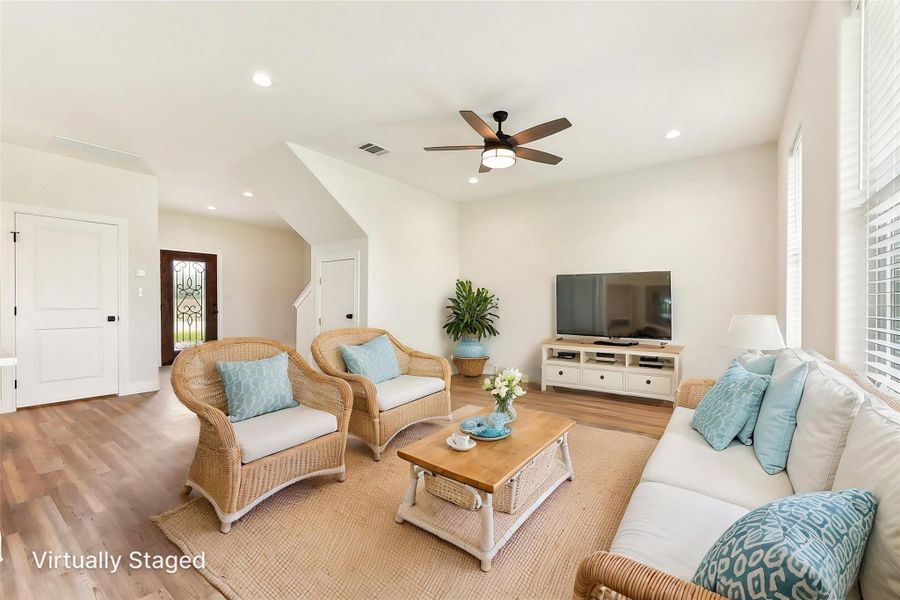 Virtually Staged Living room featuring wood look floors, a ceiling fan, visible vents, and recessed lighting Virtually Staged Living room featuring wood look floors, a ceiling fan, visible vents, and recessed lighting