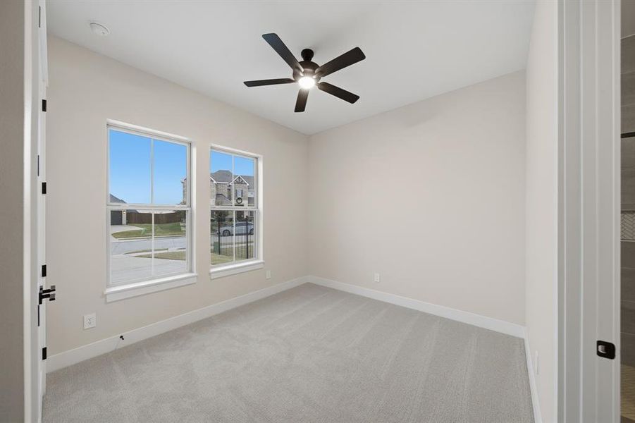 Spare room with light colored carpet and a ceiling fan