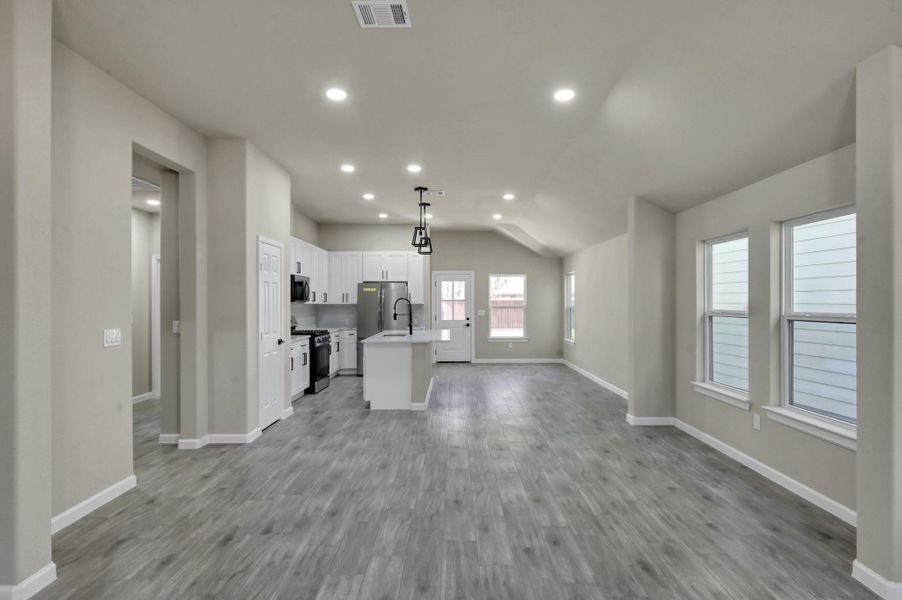 The heart of the home! This massive great room seamlessly connects the living area to the gourmet kitchen, ideal for hosting and entertaining.
