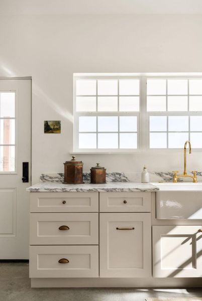 Bar with plenty of natural light, concrete flooring, and light stone counters