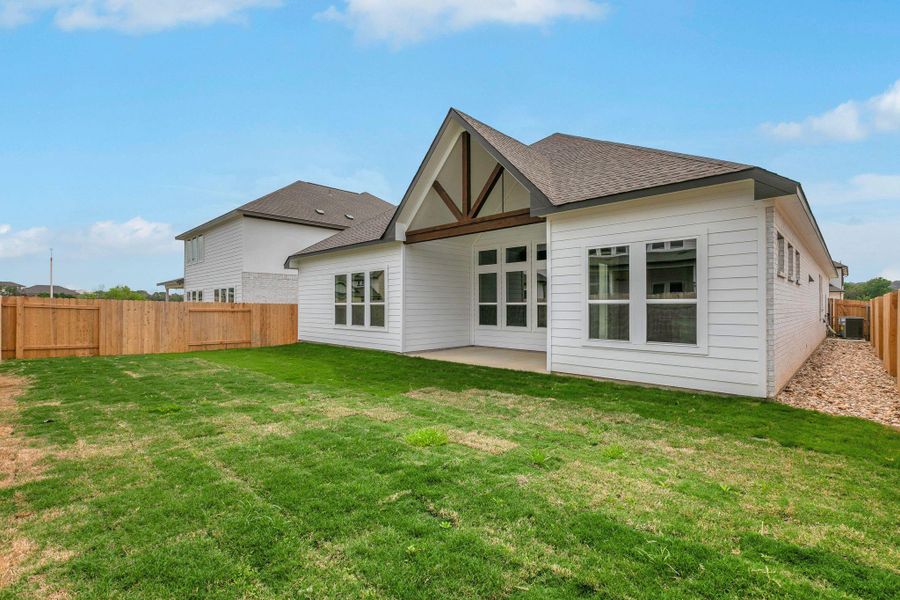 Rear view of house with a patio area, a fenced backyard, a shingled roof, and a lawn Rear view of house with a patio area, a fenced backyard, a shingled roof, and a lawn
