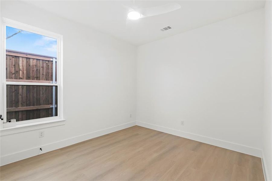 Spare room with wood finished floors and a ceiling fan