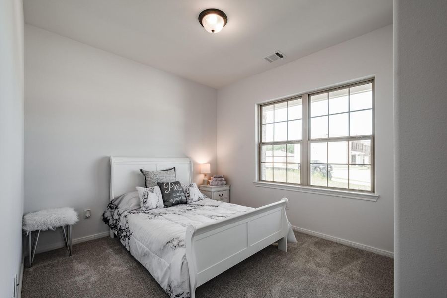 Another comfortable guest or family bedroom with soft natural light.