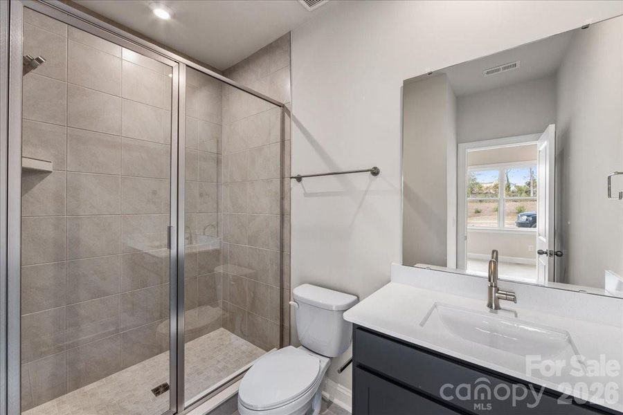 First floor full bathroom with tiled shower wall and floor pan