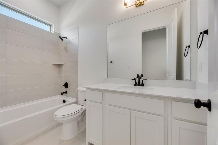 Bathroom featuring shower / washtub combination, vanity, and light tile patterned floors Bathroom featuring shower / washtub combination, vanity, and light tile patterned floors