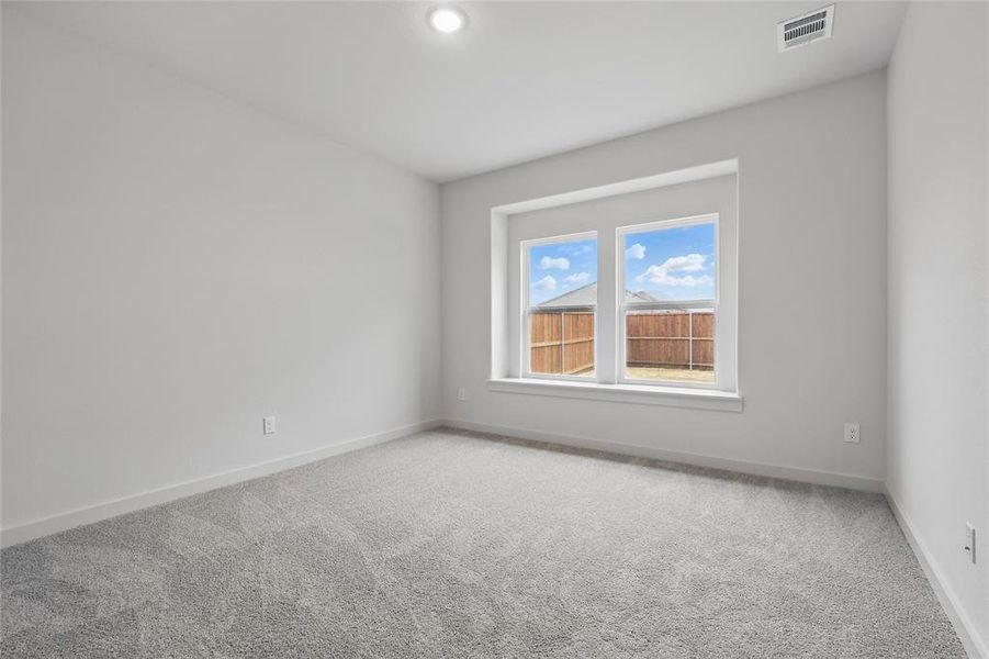 Carpeted empty room featuring baseboards