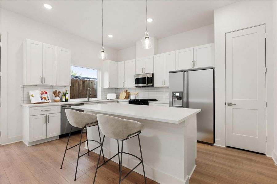 The extended breakfast bar provides additional seating—perfect for a quick meal—while keeping you connected to conversations in both the kitchen and living room. *Virtually Staged