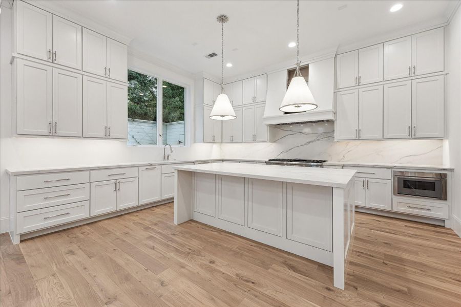 Symphony Quartz Countertops with polished nickel cabinet pulls give this kitchen a classic feeling.