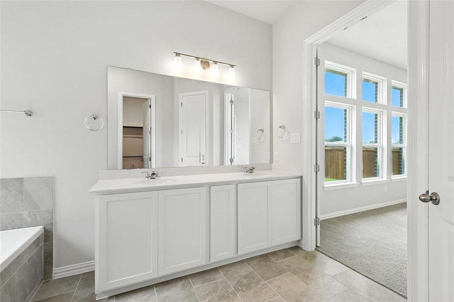 Bathroom with double vanity and baseboards Bathroom with double vanity and baseboards