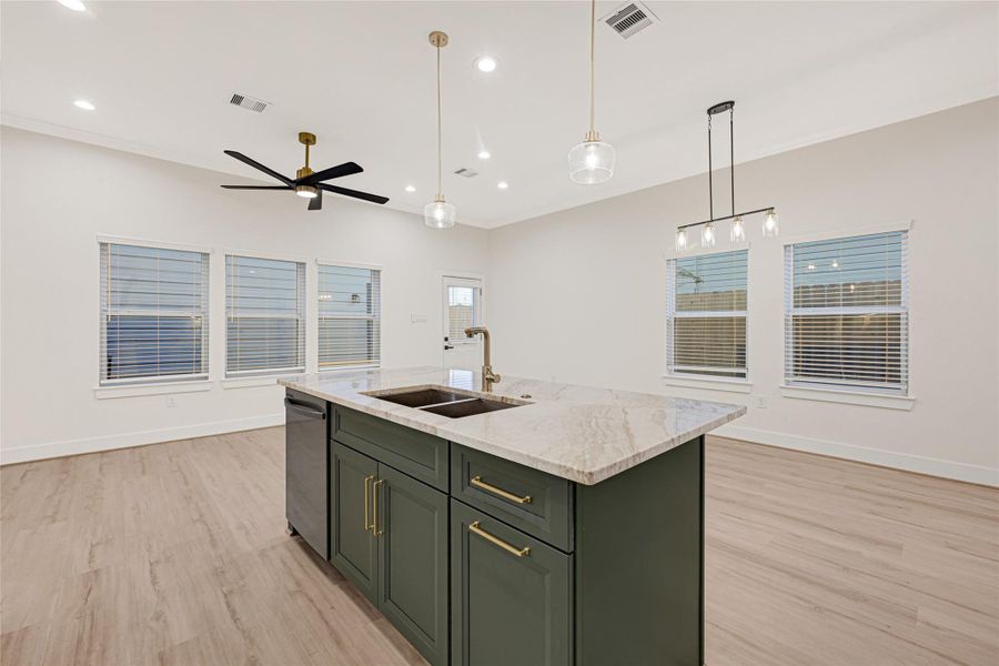 Sage green island with gold trim and quartz countertops.