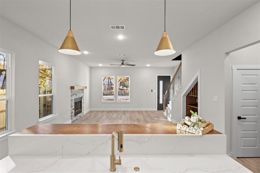 Living room featuring a fireplace, light hardwood / wood-style floors, and ceiling fan